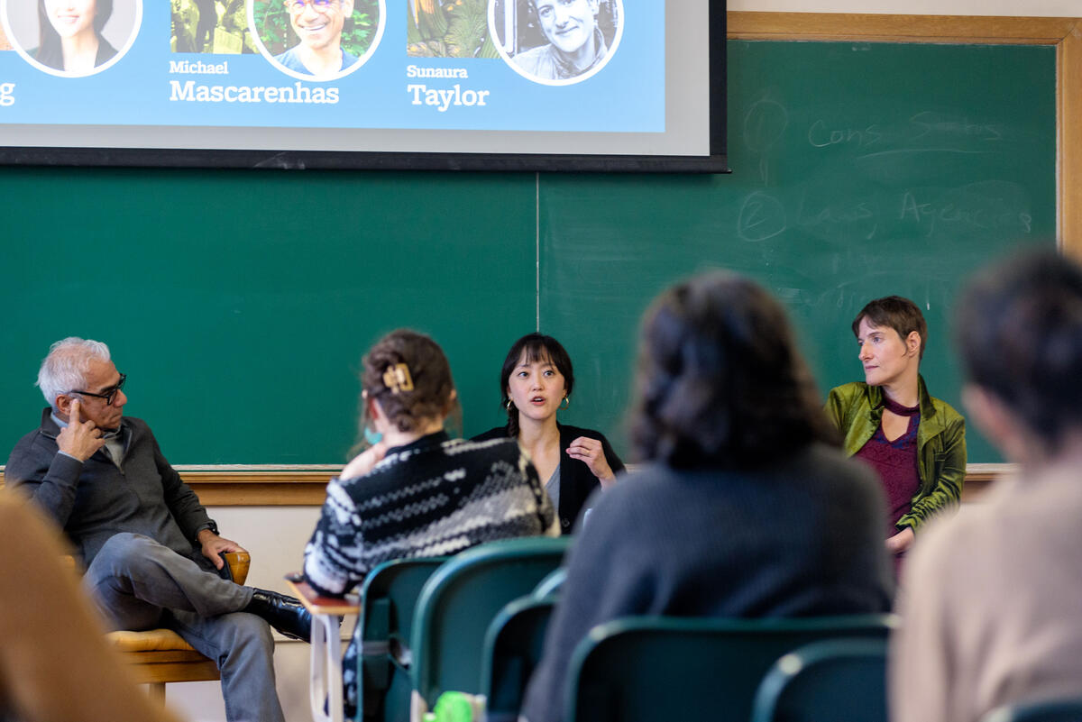 A panel of speakers in front of a group