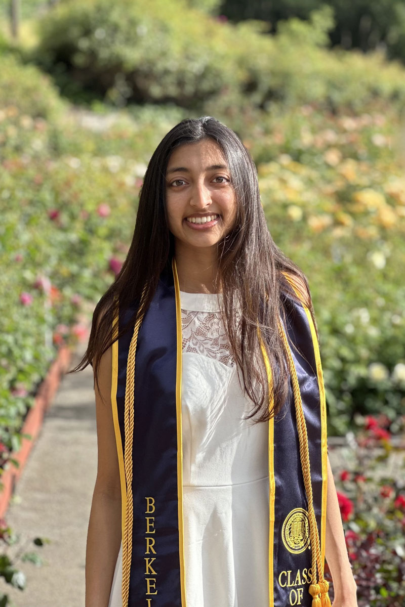 Nikita Bahadur's graduation photo in a garden of flowers