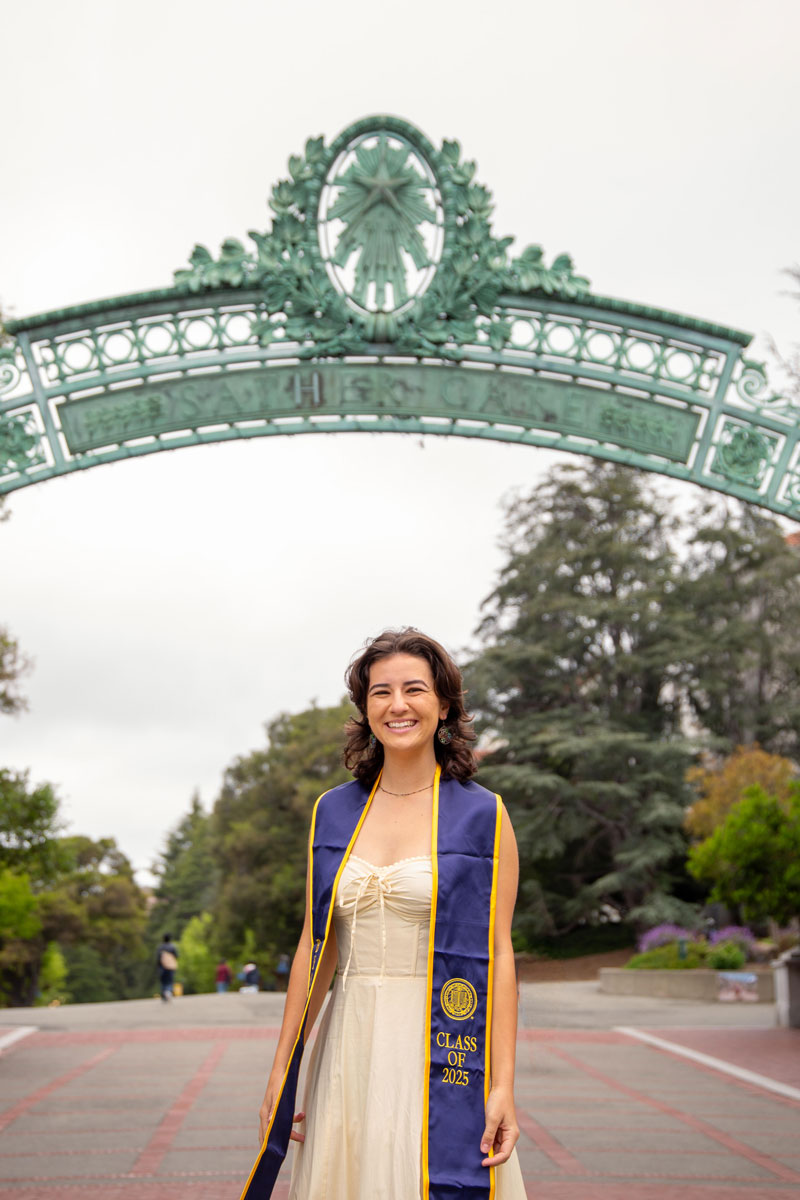 Graduation image of Alex Boren posing in front of Sather Gate