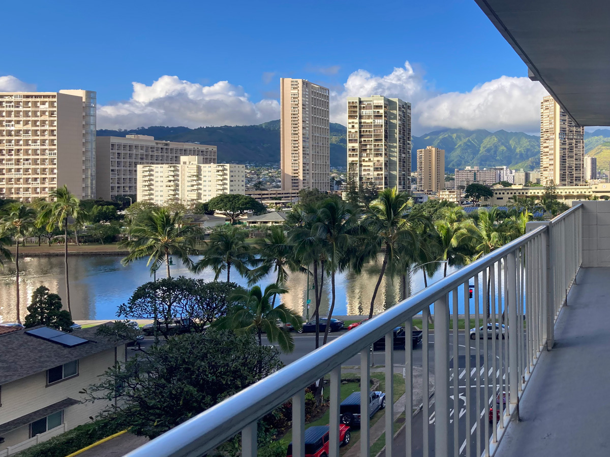 A photo of buildings in an urban, tropical environment with palm trees and water features visible