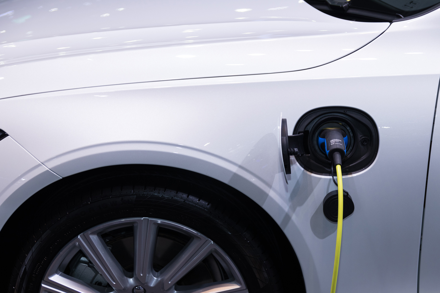 A closeup photo of a white electric vehicle charging.