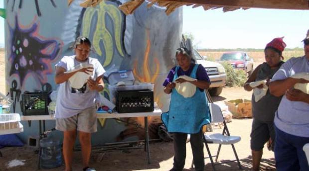 Indigenous women making bread in the desert