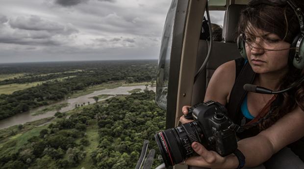 Jen Guyton taking photographs from a helicopter
