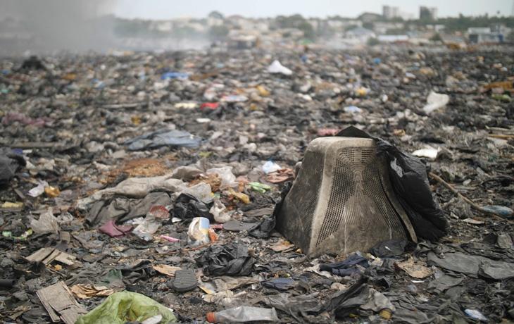 A photo of waste and trash washed ashore on a beach.