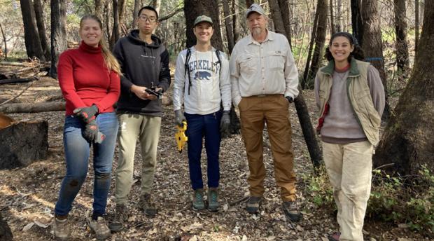 A group of students and ESPM professor Kip Will pose for a photo in a charred forest