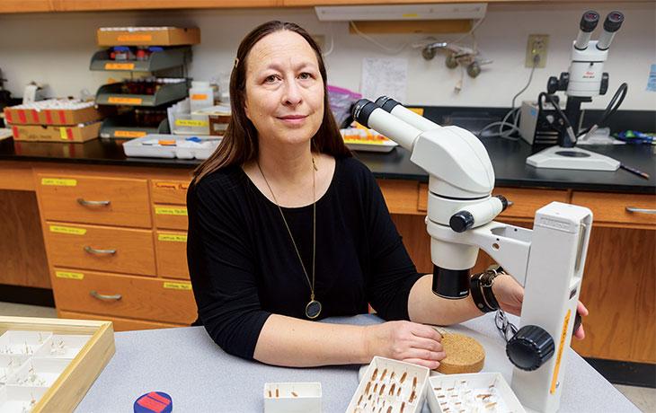 Image of Patina K. Mendez with a microscope