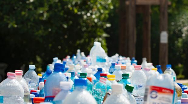 Many plastic water bottles empty in a bin.