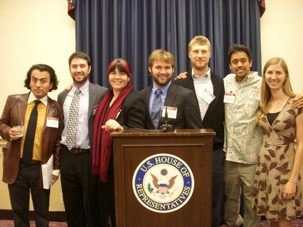 Graduate students behind House of Representatives podium. 